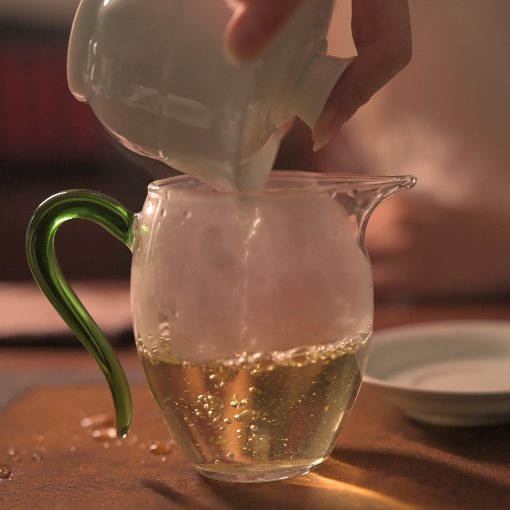 Tea & Leaf Spring 2024 Tianmen Mountain Core Region Tall Arbor Ancient Tree Raw Pu-erh Tea 200g – Lifestyle Image Holding Wrapped Tea Cake with Brewed Tea Cup