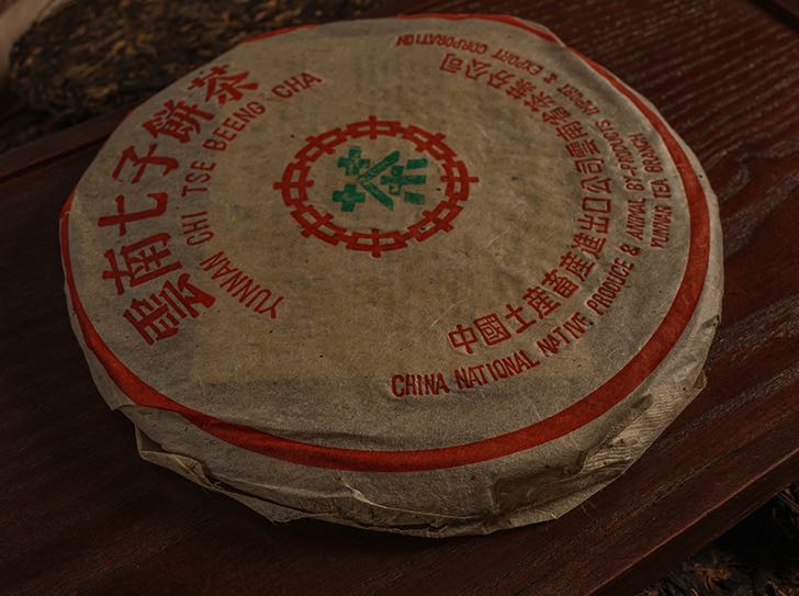 Vintage 1995 Bulang ancient tree Pu’erh cake wrapped in traditional paper — showcasing the old tree Pu’erh taste and how Pu’erh ages over time, with a rich ancient tree Pu’erh flavour profile.