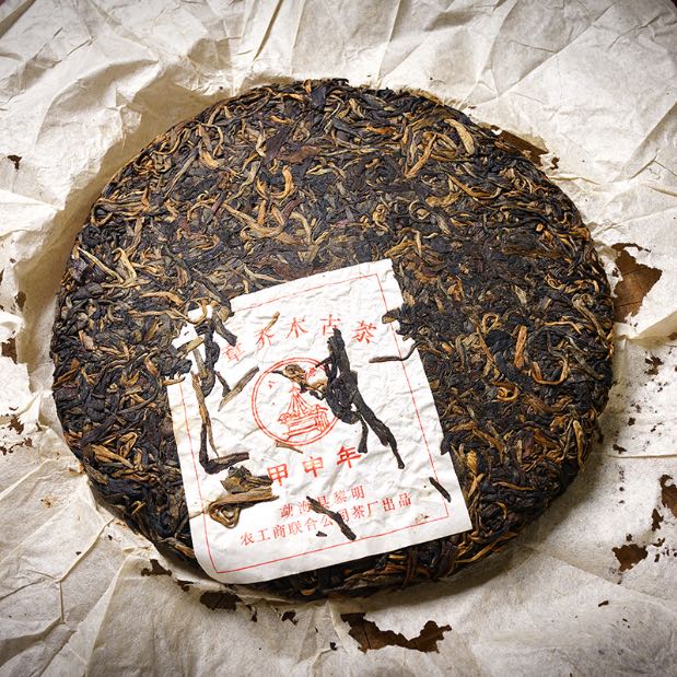 Unwrapped vintage 2004 Liming Tea Factory Ban Zhang Ancient Tree raw Pu-erh tea cake — aged Sheng Pu-erh with visible golden buds and original Liming red label on handmade paper – Tea & Leaf.